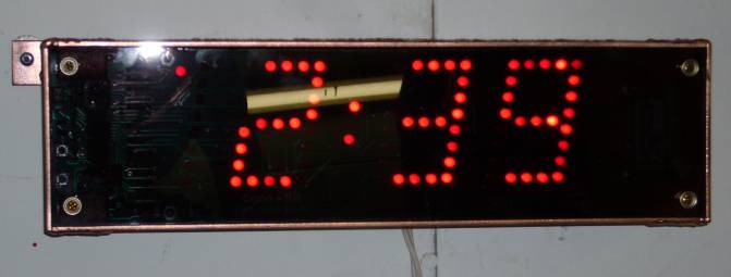 Finished copper digital clock mounted to wall